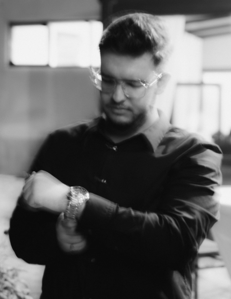 Black and white photo of Emin checking his watch